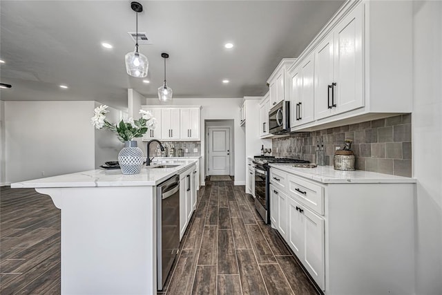 kitchen featuring white cabinetry, pendant lighting, stainless steel appliances, and dark hardwood / wood-style floors