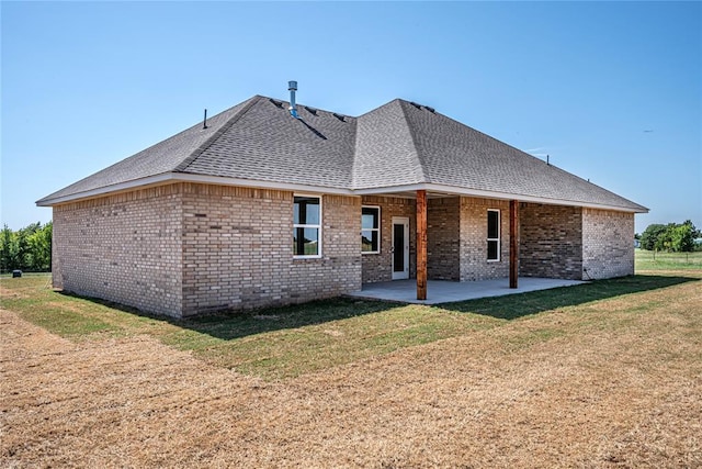 rear view of house featuring a patio area and a yard