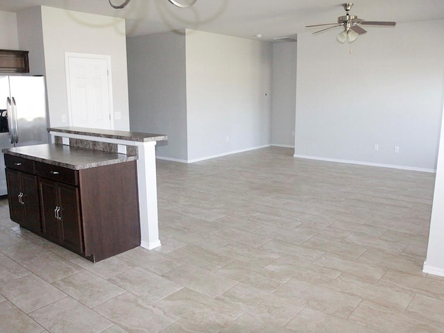 kitchen featuring stainless steel fridge with ice dispenser, dark brown cabinetry, a kitchen island, and ceiling fan