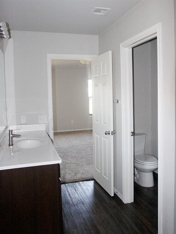 bathroom featuring vanity, hardwood / wood-style flooring, and toilet