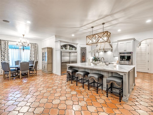 kitchen with a kitchen bar, pendant lighting, a spacious island, and appliances with stainless steel finishes