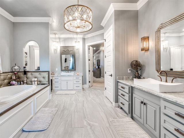 bathroom with vanity, ornamental molding, a washtub, and a chandelier