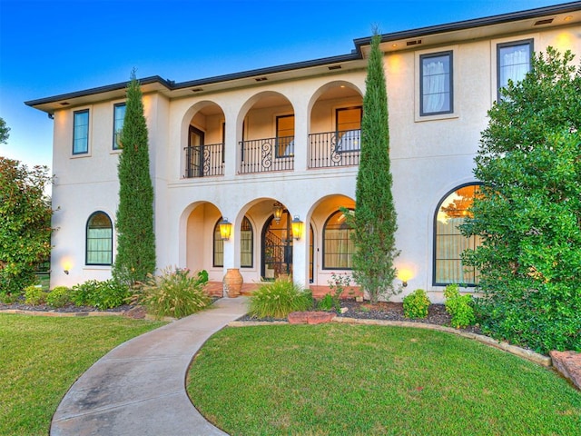 mediterranean / spanish-style home featuring a front yard