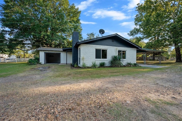 exterior space with a carport, a garage, and a front yard