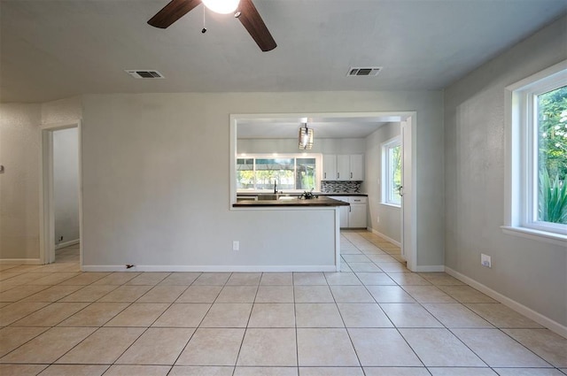 unfurnished living room featuring ceiling fan and light tile patterned floors