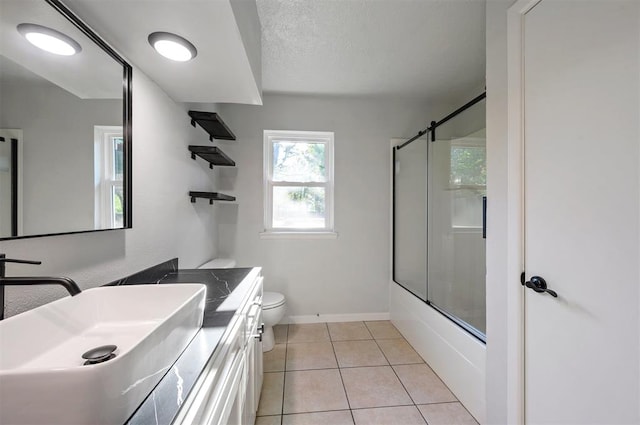 full bathroom featuring tile patterned flooring, a textured ceiling, toilet, shower / bath combination with glass door, and vanity