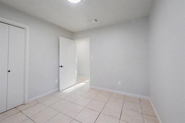 unfurnished bedroom with a closet and light tile patterned floors