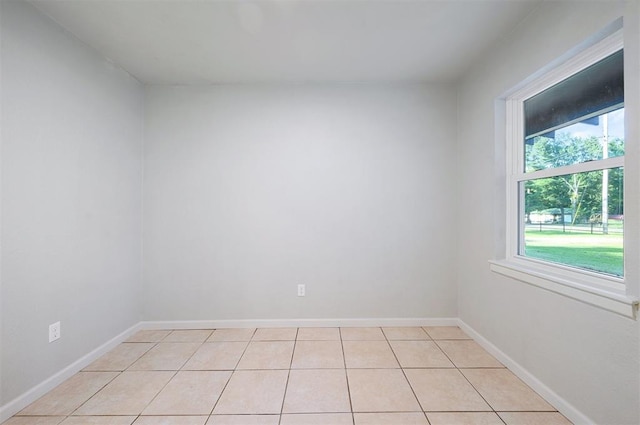 empty room with light tile patterned floors and a healthy amount of sunlight