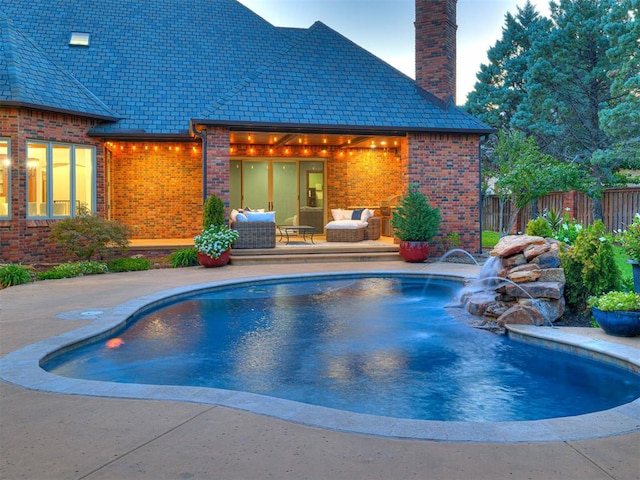 view of pool with a patio area and pool water feature