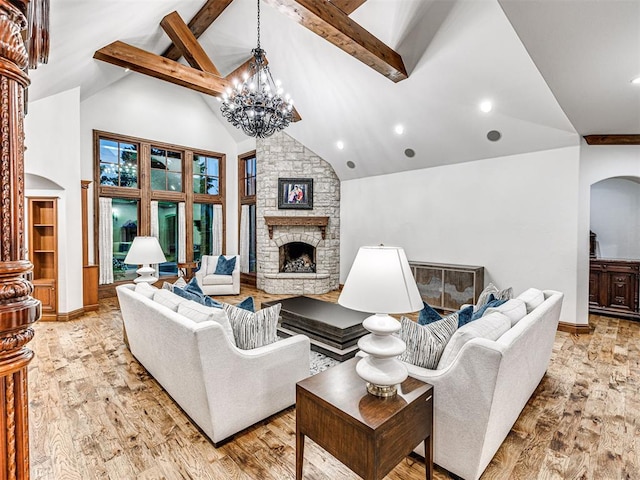 living room featuring high vaulted ceiling, a chandelier, beamed ceiling, a fireplace, and light hardwood / wood-style floors