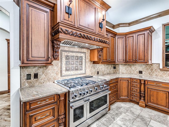 kitchen with light stone counters, tasteful backsplash, double oven range, and custom exhaust hood