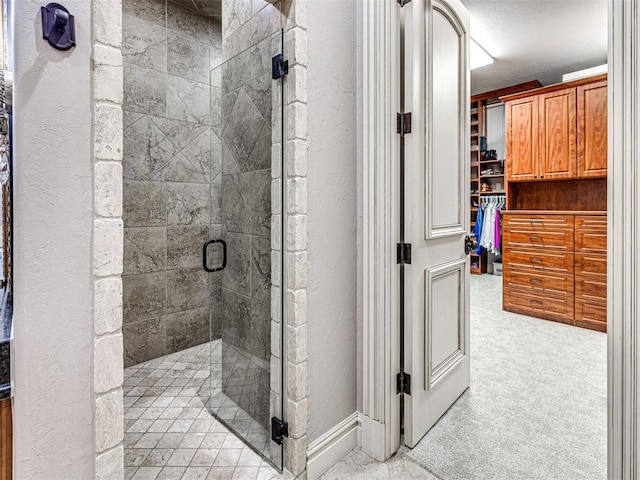 bathroom with a textured ceiling and a shower with door