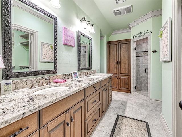 bathroom with crown molding, vanity, and an enclosed shower