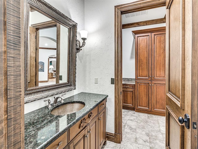 bathroom with vanity and ornamental molding