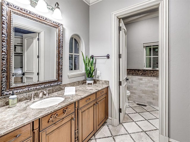 bathroom with tile patterned flooring, vanity, ornamental molding, and toilet