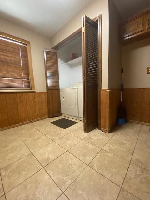 laundry area with light tile patterned flooring, independent washer and dryer, and wooden walls