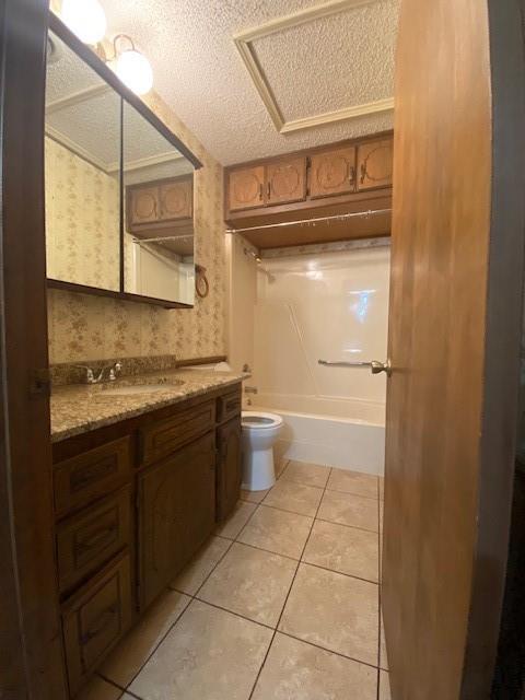 full bathroom featuring tile patterned floors, vanity, a textured ceiling, and toilet