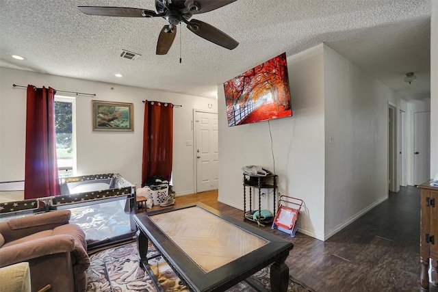 living room featuring a textured ceiling, dark hardwood / wood-style floors, and ceiling fan