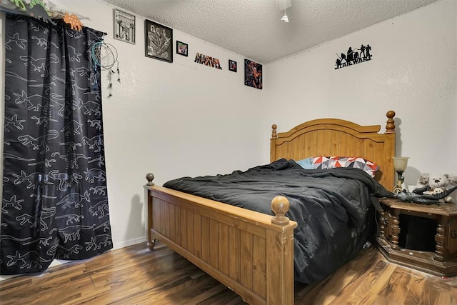 bedroom with a textured ceiling and hardwood / wood-style flooring