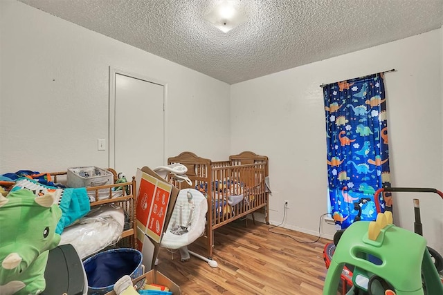 bedroom featuring hardwood / wood-style floors and a textured ceiling