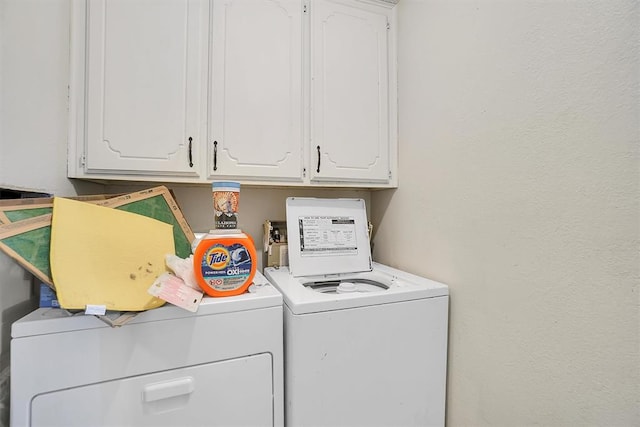 washroom with washing machine and clothes dryer and cabinets