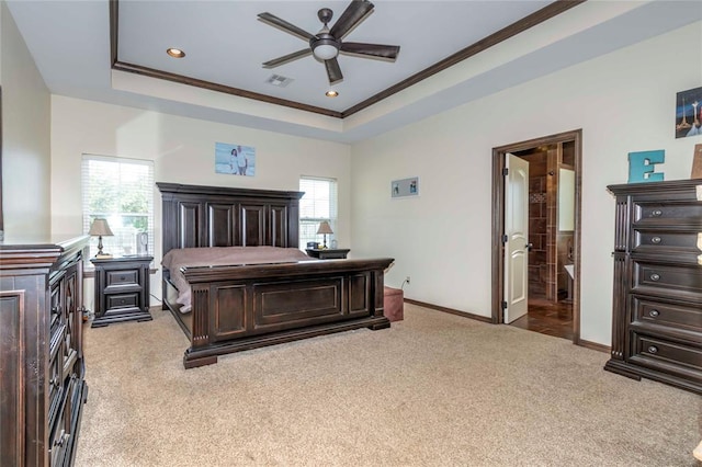 bedroom featuring ceiling fan, a raised ceiling, connected bathroom, and multiple windows