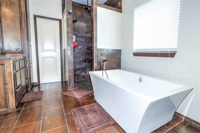 bathroom featuring tile patterned flooring, vanity, and separate shower and tub