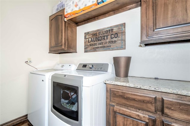 washroom with cabinets and washing machine and clothes dryer