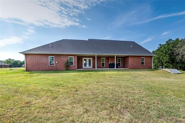 rear view of property featuring a yard and french doors