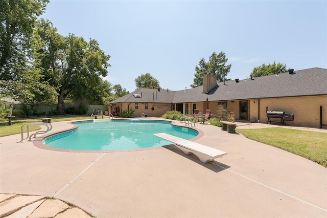 view of pool with a yard, a diving board, a patio area, and a grill