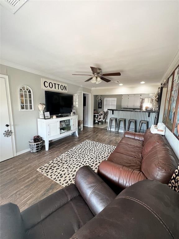 living room featuring hardwood / wood-style flooring, ceiling fan, and ornamental molding