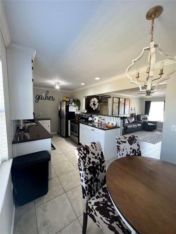 tiled dining space featuring ceiling fan with notable chandelier and crown molding