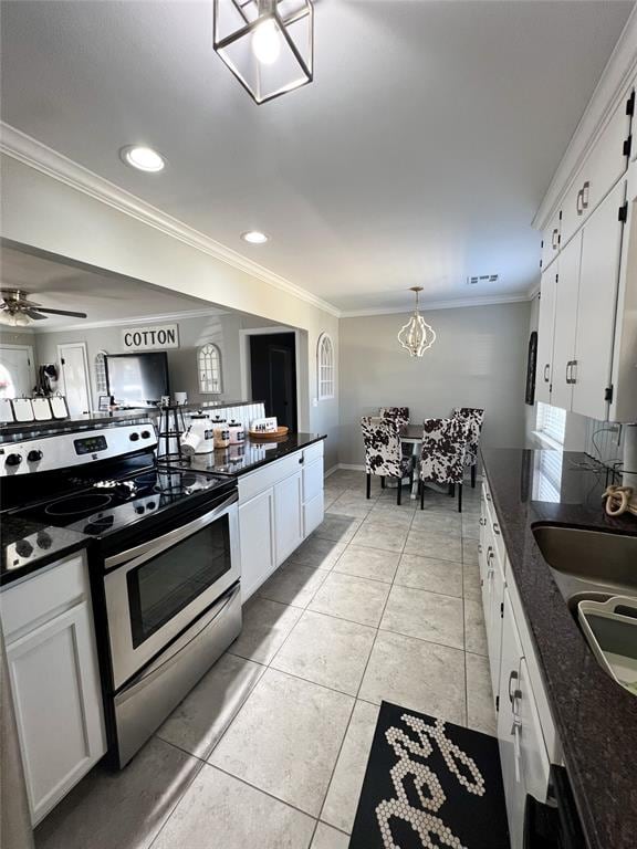 kitchen with stainless steel range, white cabinets, crown molding, and dark stone counters