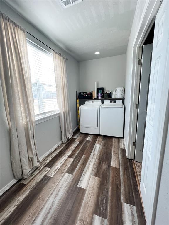 clothes washing area featuring washer and clothes dryer and dark hardwood / wood-style floors