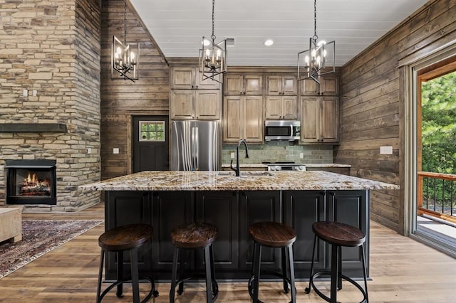 kitchen featuring plenty of natural light, a large island with sink, and appliances with stainless steel finishes