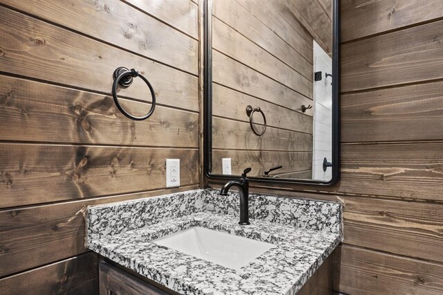 bathroom featuring vanity and wooden walls