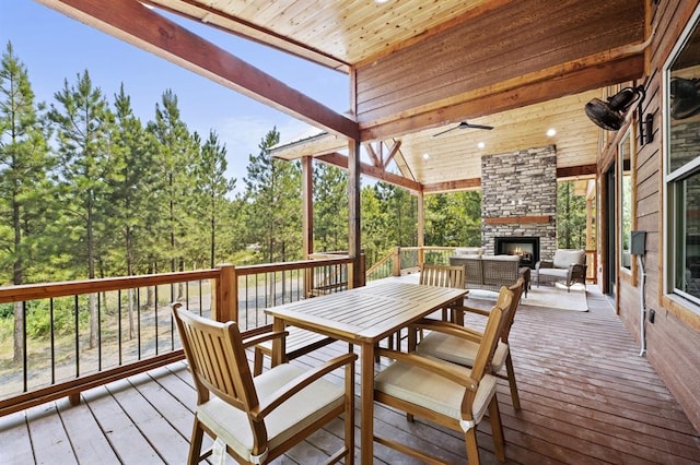 wooden deck featuring an outdoor stone fireplace