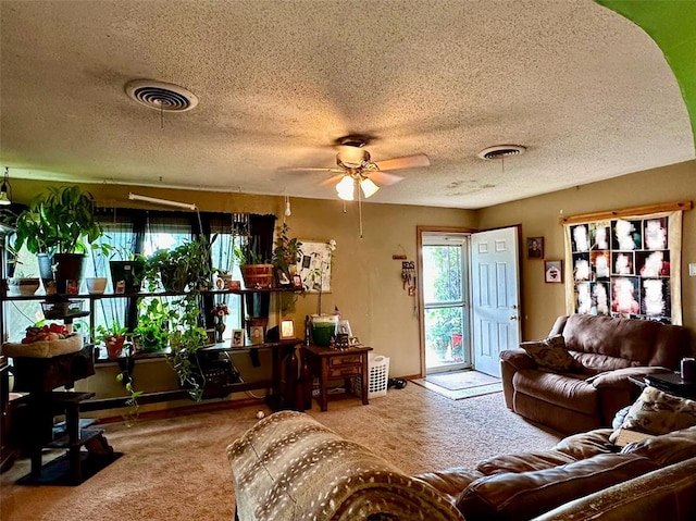 carpeted living room with ceiling fan and a textured ceiling