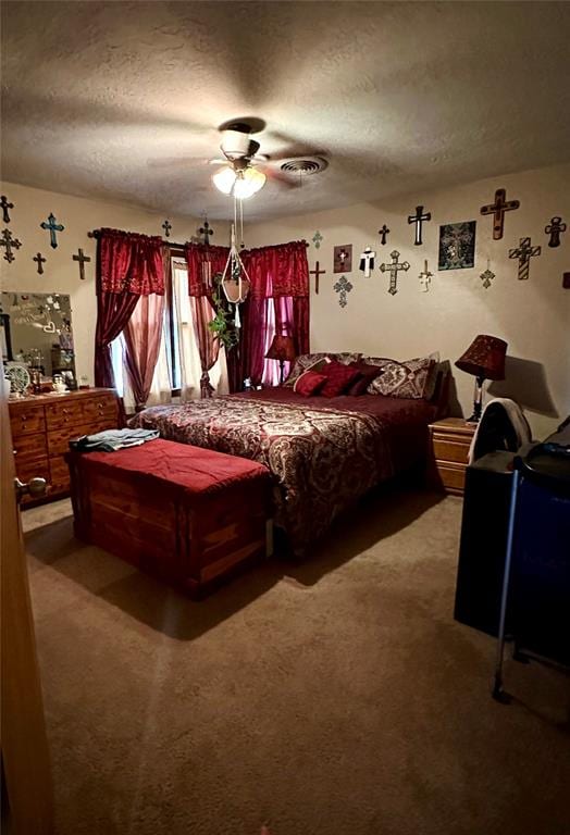 carpeted bedroom with ceiling fan and a textured ceiling