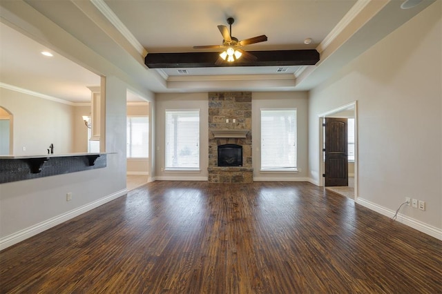 unfurnished living room with a stone fireplace, ceiling fan, crown molding, and dark hardwood / wood-style flooring