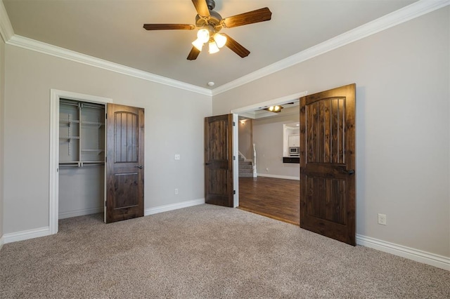 unfurnished bedroom with carpet, a closet, ceiling fan, and crown molding