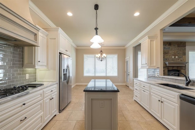 kitchen with a center island, white cabinets, sink, appliances with stainless steel finishes, and tasteful backsplash