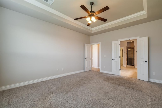 unfurnished bedroom featuring a tray ceiling, ceiling fan, and ornamental molding