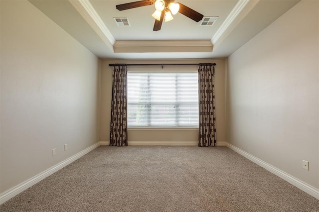 carpeted empty room featuring ceiling fan, crown molding, and a tray ceiling