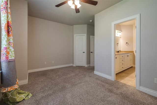 unfurnished bedroom featuring connected bathroom, ceiling fan, sink, and light carpet