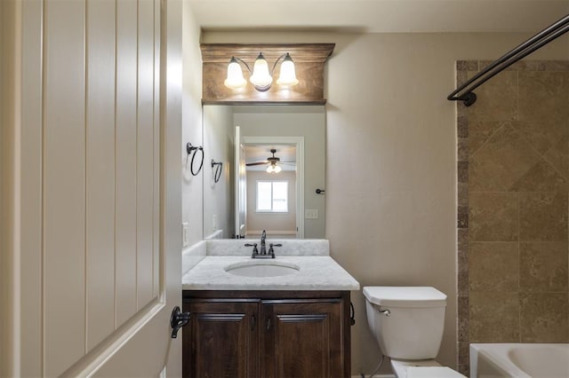 full bathroom featuring tiled shower / bath, ceiling fan, vanity, and toilet