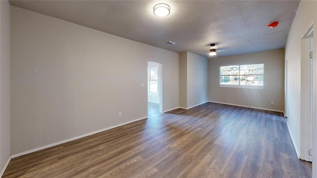 unfurnished room featuring dark hardwood / wood-style flooring and a textured ceiling