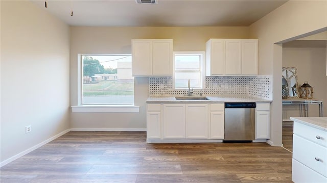 kitchen with stainless steel dishwasher, white cabinets, sink, and hardwood / wood-style floors