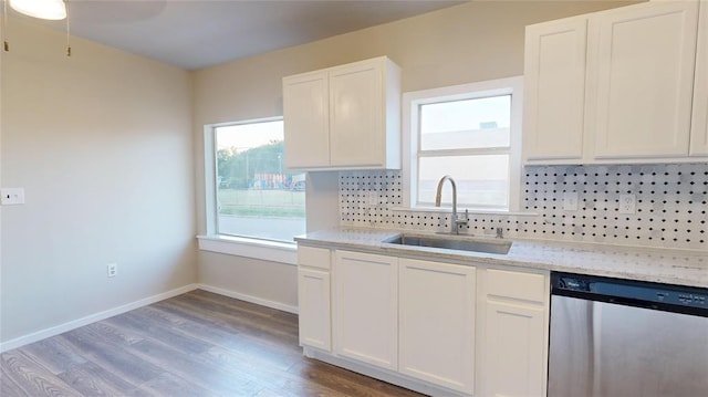 kitchen with dishwasher, white cabinets, sink, hardwood / wood-style flooring, and tasteful backsplash