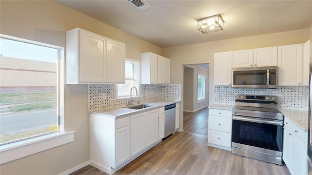 kitchen featuring backsplash, sink, white cabinets, and stainless steel appliances